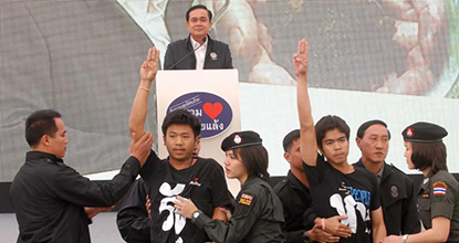 Khon Kaen students in t-shirts with an anti-coup message give the anti-coup salute in front of Prime Minister Prayut Chan-o-cha's stage in Khon Kaen.