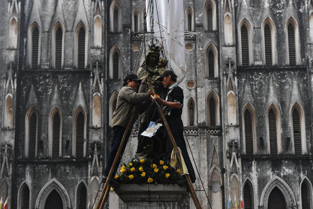 Workers polish a statue of Regina Pacis (Queen of Peace) in front of Hanoi's cathedral. Archbishop of Hanoi, Pierre Nguyen Van Nhon, was among 20 new cardinals named by Pope Francis early this month. — AFP