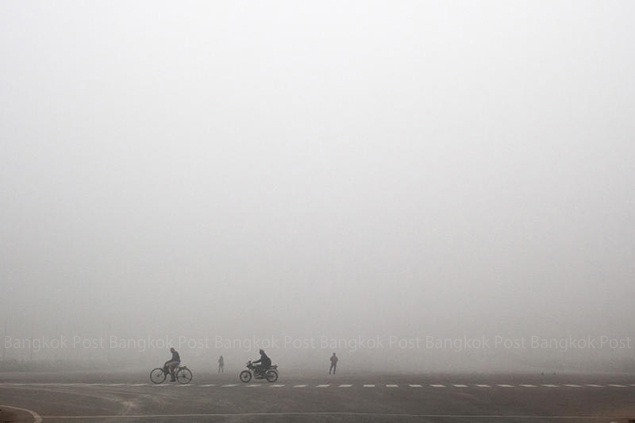Commuters make their way amidst morning fog in New Delhi. Cold wave swept across large parts of north India as fog disrupted road, rail and air traffic in a few areas. — AP