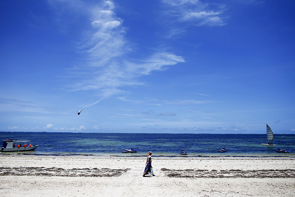A woman walks by the beach of Kenya's coastal city of Mombasa. — Reuters
