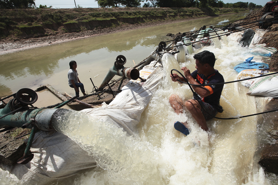 Farmers in Sam Chuk district pump water out of a canal. Photo by Patipat Janthong.