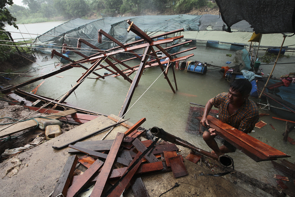 Villagers remove the structure of a house that collapsed into the Noi River in Tha Chang district, Sing Buri, when the riverbank subsided after erosion caused by the rapid discharge of water from a canal. Photo by Patipat Janthong