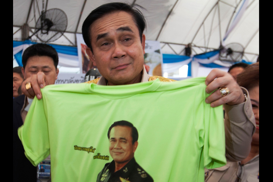 Prime Minister Prayut Chan-o-cha checks out a T-shirt with his face and
