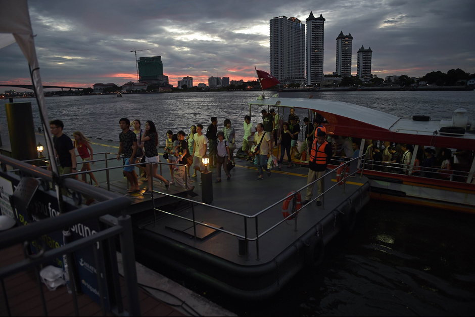 Commuters, including tourists, disembark from a ferry along the Chao Phraya river in Bangkok. - AFP
