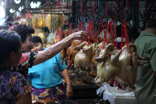 A woman is choosing a chicken in preparing for the Chinese New Year in Yaowarat on Tuesday. (Bangkok Post photo)