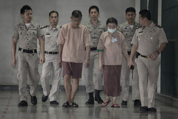 Apiruj Suwadee and his wife Wanthanee, the parents of Thanpuying Srirasm Suwadee, formerly Princess Srirasm, are taken to the Criminal Court to hear the verdict on Wednesday. The court sentenced the couple to two years and six months in prison each for lese majeste. (Photo by Pattanapong Hirunard)