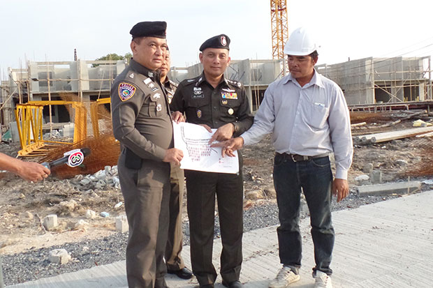 Assistant national police chief Suwira Songmeta (centre) leads a team of police to inspect and seize 100 housing units at the Bangkok Marina Resort & Spa project in Samut Prakan on April 23. (Photo by Sutthiwit Chayutworakan)