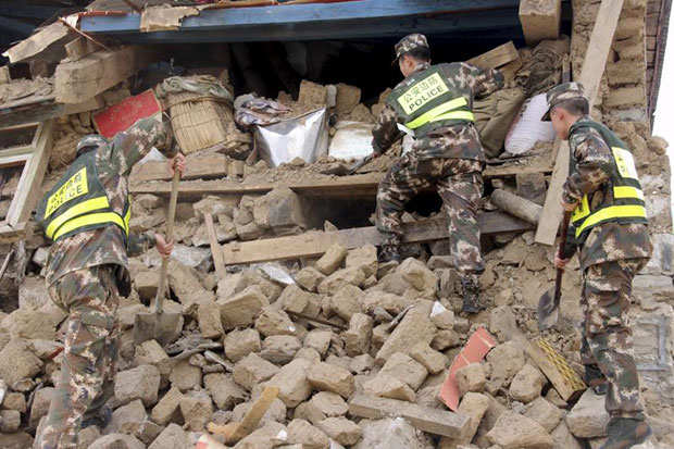 Chinese police search ruins of buildings damaged by the 7.9-magnitude earthquake that hit Nepal on Saturday, in Gyirong county, Tibet Autonomous Region, China, on April 26, 2015. (Reuters photo)