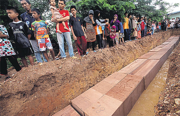 Coffins containing the bodies of Rohingya boat people line a local Muslim cemetery in Songkhla's Hat Yai district, after being recovered from a mass grave earlier this month in Padang Besar. (Photo by Pornprom Satrabhaya) Coffins containing the bodies of Rohingya boat people line a local Muslim cemetery in Songkhla's Hat Yai district, after being recovered from a mass grave earlier this month in Padang Besar. (Photo by Pornprom Satrabhaya)