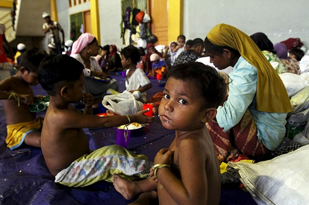 A child, believed to be Rohingya, eats inside a shelter after he was rescued along with hundreds of others from boats in Lhoksukon in Indonesia's Aceh province May 12. There has been a surge in refugees arriving from impoverished Bangladesh and Myanmar to Malaysia and Indonesia following a crackdown on trafficking by Thailand, usually the first destination in the region's people-smuggling network. (Reuters photo)