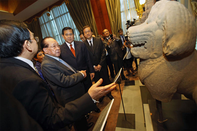 Cambodian Foreign Minister Hor Namhong and Thai counterpart Tanasak Patimapragorn inspect one of the artefacts returned on Saturday. (Photo by Pormprom Satrabhaya)