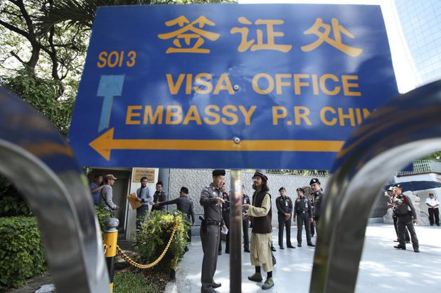 Chinese embassy officials refused to come out of the Din Daeng mission, so this representative of the Muslim for Peace Foundation asked a policeman to take his letter asking the Chinese to disclose how they are treating the 109 Uighurs forced back to China last week. (Photo by Patipat Janthong)