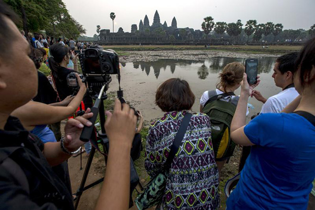 Tourists gather to watch and take pictures of Cambodia's world famous Angkor Wat temple during sunrise in Siem Reap on March 20, 2015. (Reuters photo)