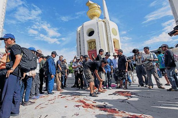 Volunteers clear the blood away from an attack on the People's Democratic Reform Committee (PDRC) protest in which three people were killed and two wounded. The cabinet voted on Tuesday to give victims and families of the 2013-14 Bangkok Shutdown violence a total of 120 million baht in compensation. (Bangkok Post file photo)