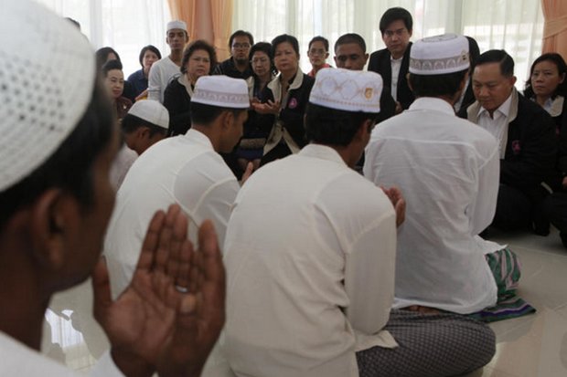 Pol Gen Adul Sangsingkeo (right) Minister of Social Development and Human Security, prayed Thursday with 24 Rohingya human trafficking victims at a welfare centre in Pathum Thani. The migrants will travel to the US for resettlement next week. (Photo by Apichit Jinakul)