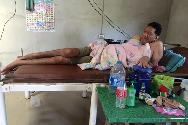 Pornchai Saosri, 26, is too ill to walk or even stand, and is here seen confined to his bed at his home in Prasat district, Surin, on Monday. (Photo by Nopparat Kingkaew)