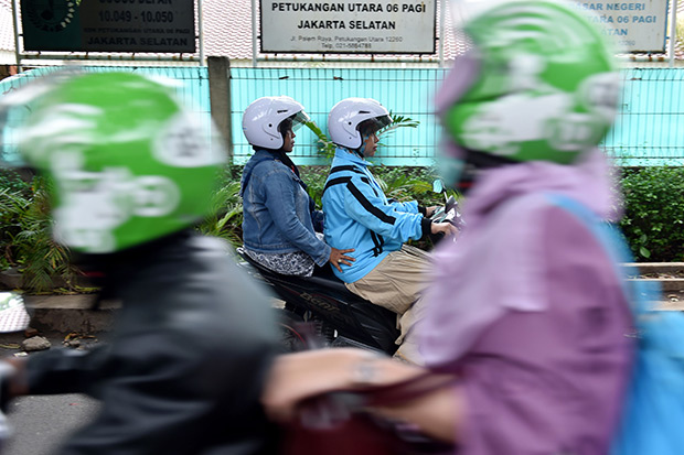 This picture taken on Nov 22 shows a female motorcycle taxi driver (centre right) travelling with a passenger in Jakarta. A flurry of new motorbike taxi options have in the past year appeared in the metropolis of 10 million, giving Indonesia's growing middle class a greater choice of transport to get through some of the world's worst traffic jams. (AFP photo) This picture taken on Nov 22 shows a female motorcycle taxi driver (centre right) travelling with a passenger in Jakarta. A flurry of new motorbike taxi options have in the past year appeared in the metropolis of 10 million, giving Indonesia's growing middle class a greater choice of transport to get through some of the world's worst traffic jams. (AFP photo)
