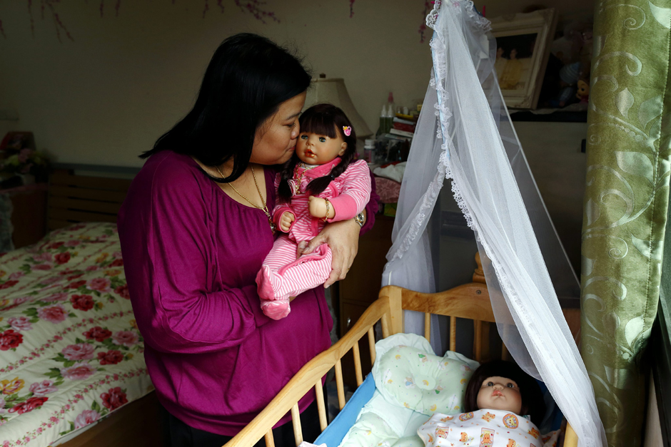 Time to go to bed: The owner cradles one of her dolls as she sends them to 'sleep'.