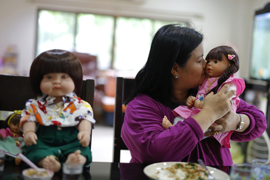 Ms Ratchada has a meal with her Child Angel dolls at her house.