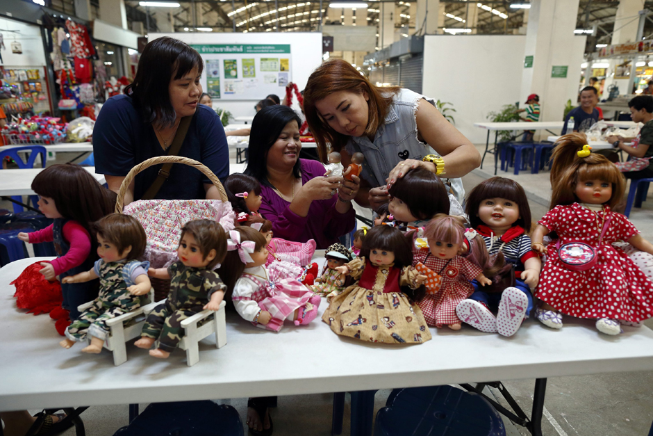 Ms Ratchada talks to her friends Nipaporn Pornchaipimolpunt (left) and Nita Kangvanchaivanich (right), as they get together with their Child Angel dolls at the market.