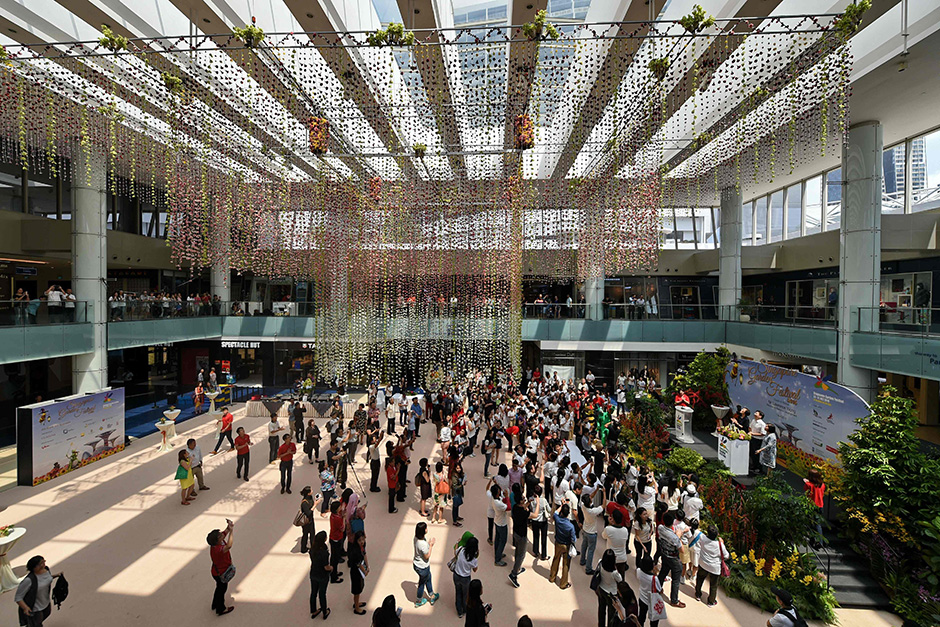 People gather to witness the launch for the biennial Singapore Garden Festival with the largest floral chandelier exhibited at Marina Square shopping centre. The largest floral chandelier was to set the new Guinness World Record. — AFP