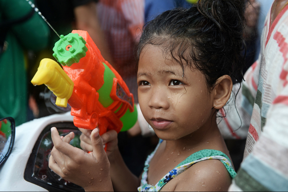 A girl fires her water gun on Khao San road. - AFP