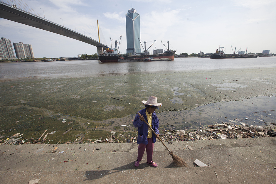 A worker sweeps the steps along the Chao Phraya River near Rama IV Bridge in Bangkok on May 24, as the water level continues to fall. - Pawat Laopaisarntaksin
