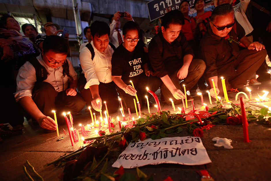 A group of activists hold a candle light vigil in remembrance of the violent clashes between soldiers and red-shirt protesters at the Ratchaprasong intersection on May 19, 2010. - Jiraporn Kuhakan