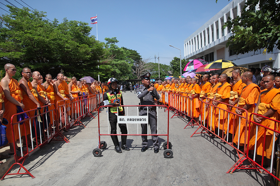 About 500 Buddhist monks and lay followers on May 26 wait to greet Phra Dhammajayo, abbot of Wat Dhammakaya, outside Khlong Luang police station in Pathum Thani. The abbot's lawyer later informed police Phra Dhammajayo fainted while being carried into a van and could not travel to nearby Chaeng Wattana in adjoining Bangkok to acknowledge charges of money laundering and receiving 1.2 billion baht in stolen funds brought against him by the Department of Special Investigation. - Wichan Charoenkiatpakul