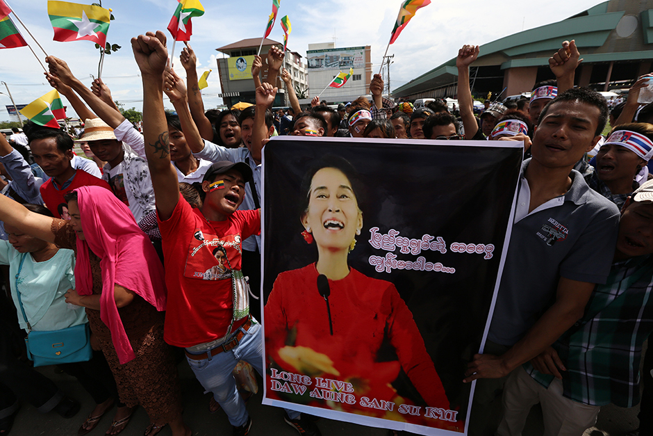 Thousands of Myanmar migrant workers wave national flags and cheer, as they await Suu Kyi's arrival at the fishing village in Samut Sakhon. - Seksan Rojjanametakun