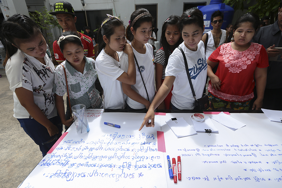These Myanmar women prepare a large sign outlining their working conditions and demands to Suu Kyi. - Patipat Janthong