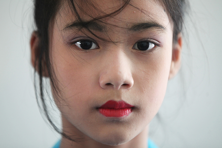 Children of Myanmar workers in Thailand get dressed up and wear makeup to greet Suu Kyi. - Seksan Rojjanametakun