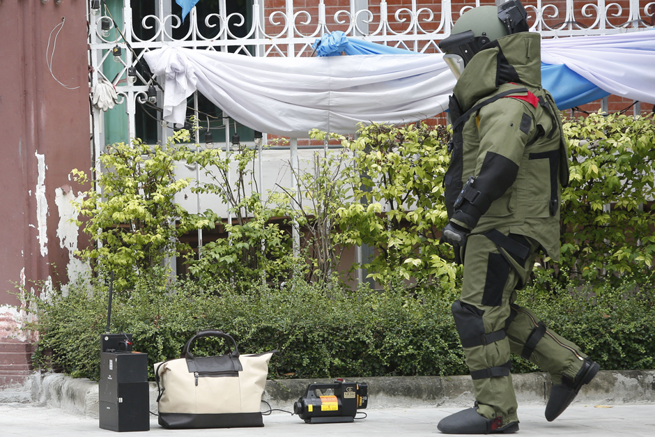 An Explosives Ordnance Disposal (EOD) officer approaches suspicious bags left at the Teachers' Council of Thailand building. The officer finds only books inside them. - Pattarapong Chatpattarasill