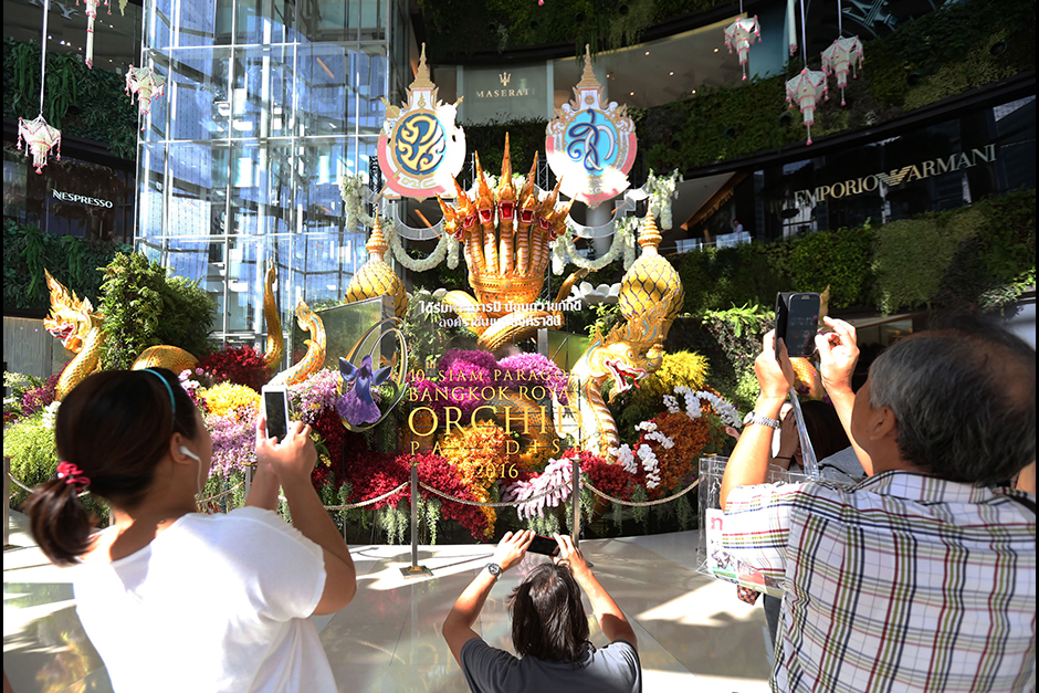 People take photos at the entrance of the 10th Siam Paragon Bangkok Orchid Paradise 2016. - Jiraporn Kuhakan