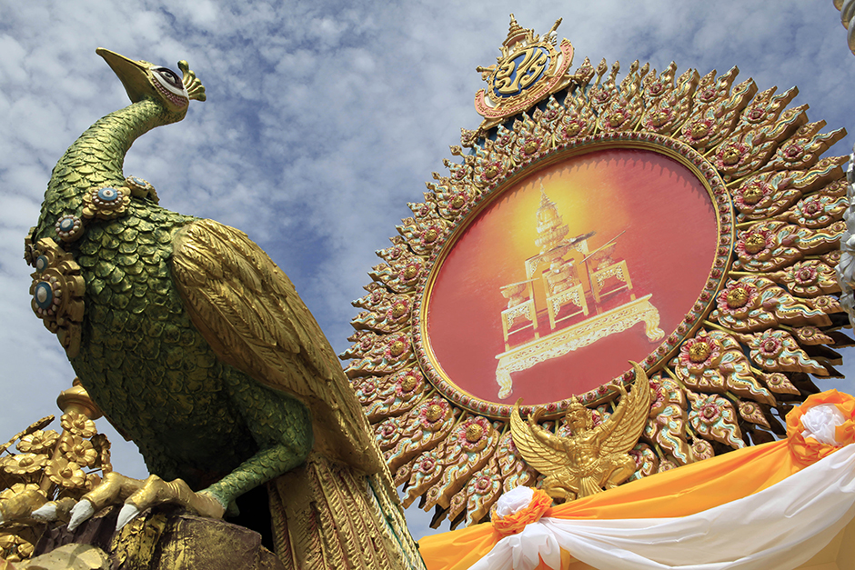 An ornamental peacock adorns elaborate decorations on Ratchadamnoen Avenue to commemorate the 70th anniversary of His Majesty the King's accession to the throne on June 9, and the seventh-cycle birthday anniversary of Her Majesty the Queen on Aug 12. - Apichart Jinakul