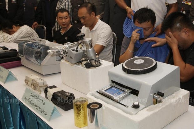 Five Chinese suspects were arrested Sunday for manufacturing and using fake credit cards in Bangkok. They appear here along with the equipment allegedly used to make the bogus cards. (Photo by Apichit 
Jinakul)