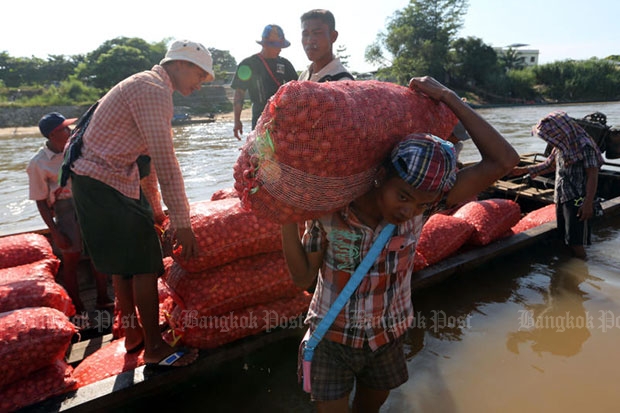 Workers are helping to unload the onion at Moei Reiver that borders Thailand and Myanmar in Tak province. (Bangkok Post file photo)