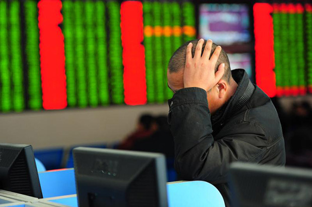 A Chinese investor looks at a computer screen showing stock information at a brokerage house in Fuyang, Anhui province, on Thursday. (Reuters photo)