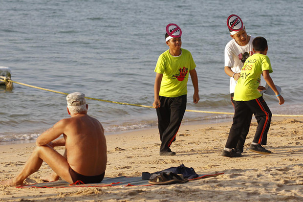 Students play near a tourist as they wear headbands to raise awareness on World Aids Day in Pattaya on Dec 1. The resort city is a main stop for visitors from Russia. (Reuters photo)