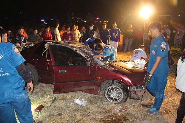 Rescue workers try to retrieve the body of the dead woman and her injured son from the wreckage of their car after it was hit by a Bangkok-bound passenger train at a railway crossing in Udon Thani on Monday night. (Photo by Yuttapong Kumnodnae)