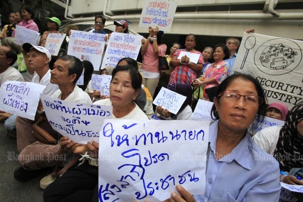 People affected by the military council’s twin orders clearing the way for the construction of several power plants and for the development of special economic zones hold placards calling on the junta to scrap the orders during a rally at Government House Tuesday. (Photo by Thanarak Khunton)