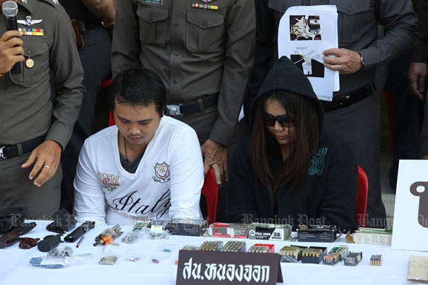 Two university students, Damrong Ounruen and Miss Pitcha-orn Phaetyanont, 21, at a police press conference on Friday, along with several handguns and more than 200 rounds of ammunition seized from them. (Photo by Pattanapong Hirunard)