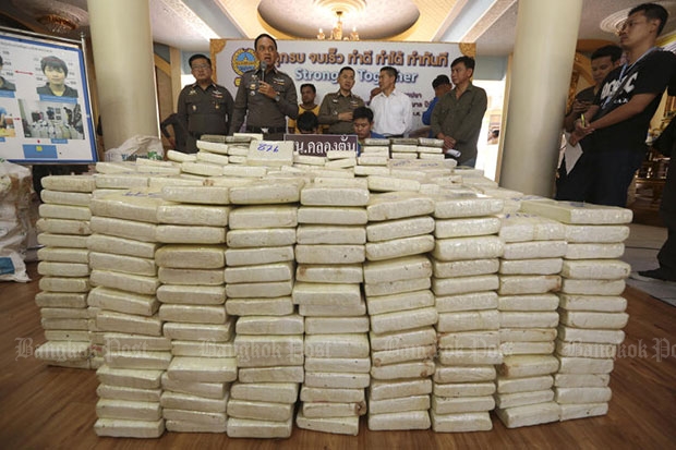 Saharat Khiewpimpa, 20, and Pawan Chankhaikhot, 22, and a pile of compressed marijuana weighing 878kg seized from them are shown at a media briefing on Thursday. (Photo by Patipat Janthong)