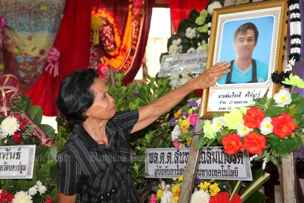 Thongkham Sichan, mother of murder victim Somkiat Sichan, mourns at a funeral ceremony held Thursday at Wat Thamma Sala in Nakhon Pathom province for the disabled deliveryman. Somkiat was stabbed and beaten to death last Sunday, and the family predicts police will line up to protect the accused, four of whom are the sons of police officers. (Photo by Wichan Charoenkiatpakul) Thongkham Sichan, mother of murder victim Somkiat Sichan, mourns at a funeral ceremony held Thursday at Wat Thamma Sala in Nakhon Pathom province for the disabled deliveryman. Somkiat was stabbed and beaten to death last Sunday, and the family predicts police will line up to protect the accused, four of whom are the sons of police officers. (Photo by Wichan Charoenkiatpakul)
