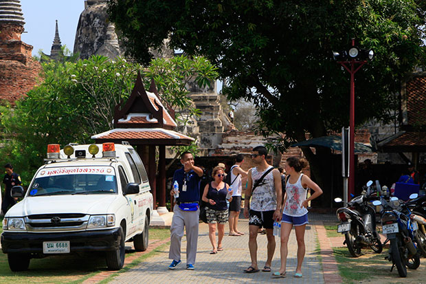 A plainclothes policeman talks to tourists at Ayutthaya Historical Park as safety measures are stepped following the assault and robbery of a German visitor. (Photo by Sunthorn Pongpao)