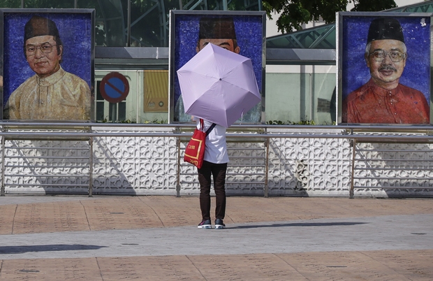 A woman looks at portraits of Malaysian prime ministers (from left) Mahathir Mohamad, Abdullah Badawi and Najib Razak in Kuala Lumpur. (EPA Photo) A woman looks at portraits of Malaysian prime ministers (from left) Mahathir Mohamad, Abdullah Badawi and Najib Razak in Kuala Lumpur. (EPA Photo)