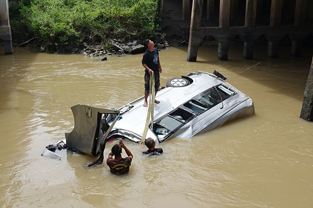 Rescue workers salvage the submerged van that carried four British tourists and their tour guide after the accident in Rayong province on Wednesday. (Photo by Jumphon Nikhomrak)