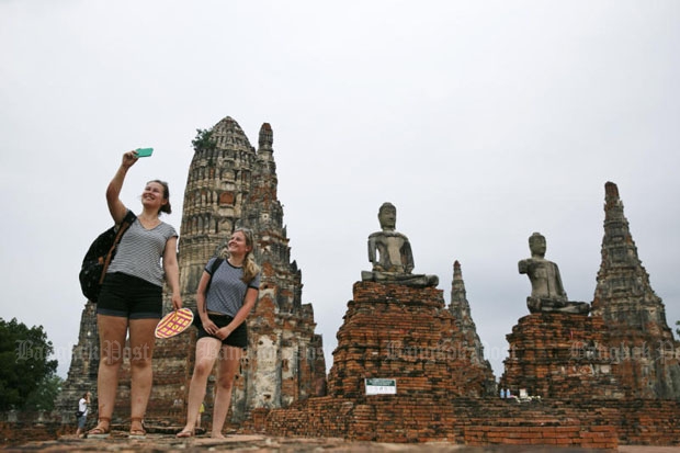 Tourists take selfies at Wat Chai Wattanaram in Ayutthaya province. The National Broadcasting and Telecommunications Commission plans to track foreign visitors' movements in the country around the clock with special SIM cards. (Photo by Seksan Rojjanametakun)