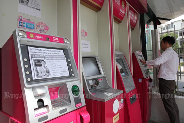 An employee posts out-of-service notices on Government Savings Bank ATMs shut down after criminals stole more than 12 million baht from the banks malware-infected automatic teller machines in six provinces. (Photo by Wichan Charoenkiatpakul)