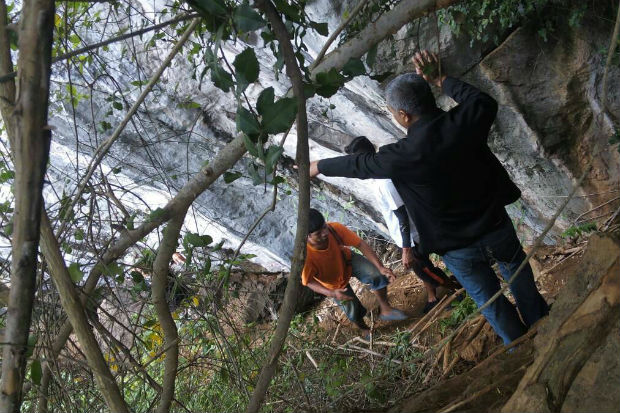 Suspect Apai Ruengvorn, 28, is taken for a crime re-enactment at the base of a cliff at Ao Nang in Krabi where an American woman was badly hurt in a fall while fleeing her attacker. (Photo by Achadtaya Chuenniran)